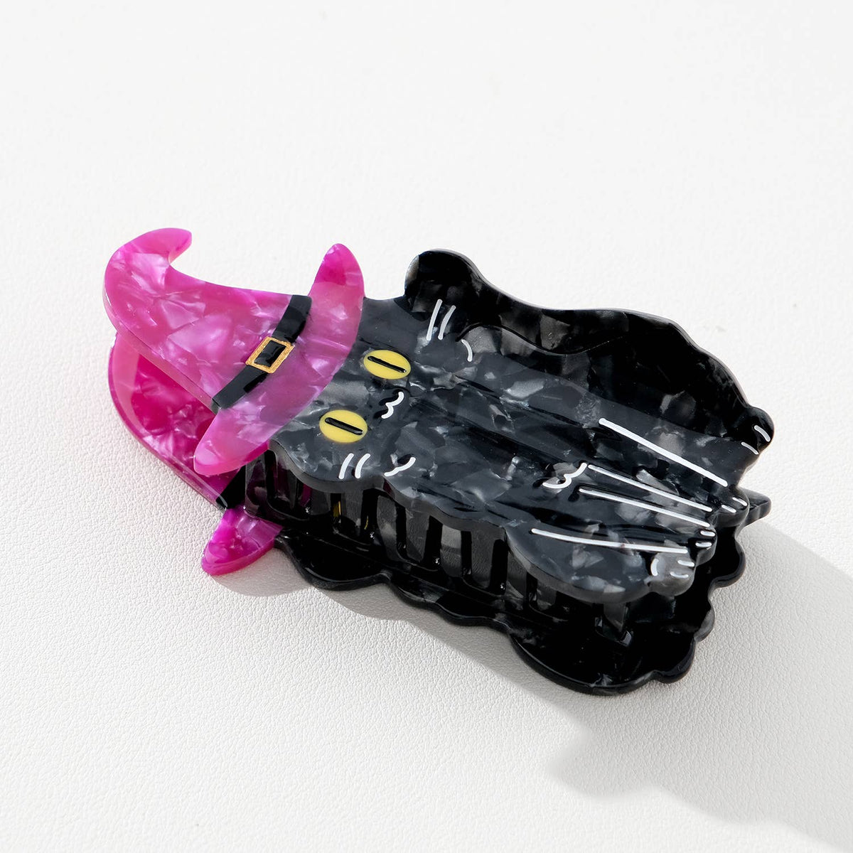 Black cat hair clip with purple witch hat on a white background