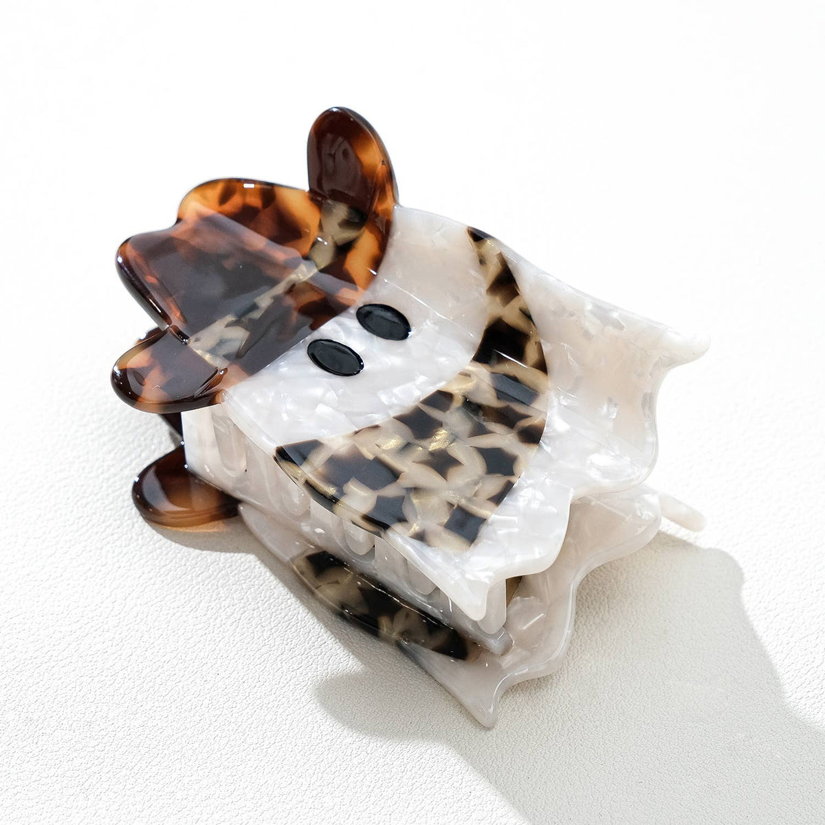 ghost-shaped hair clip with tortoiseshell cowbory scarf and hat accents on a white background