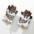 Two ghost-shaped hair clips with tortoiseshell cowbory scarf and hat accents on a white background
