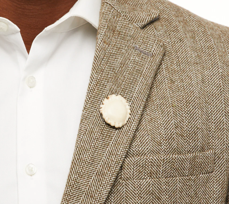 White deer burr lapel pin featured on a brown herringbone sports coat.
