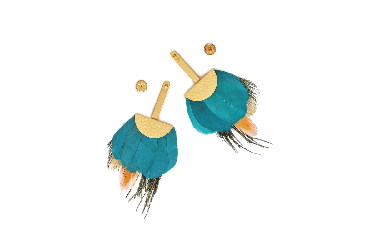 Pair of gold earrings with dangling peacock feathers shown from the back against a white background.