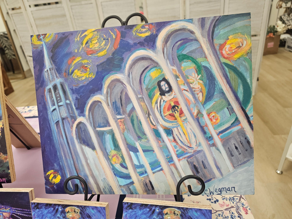 Colorful painting of a religious figure with arches on an easel.