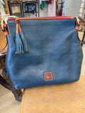 Blue leather handbag with a brand logo on a wooden surface