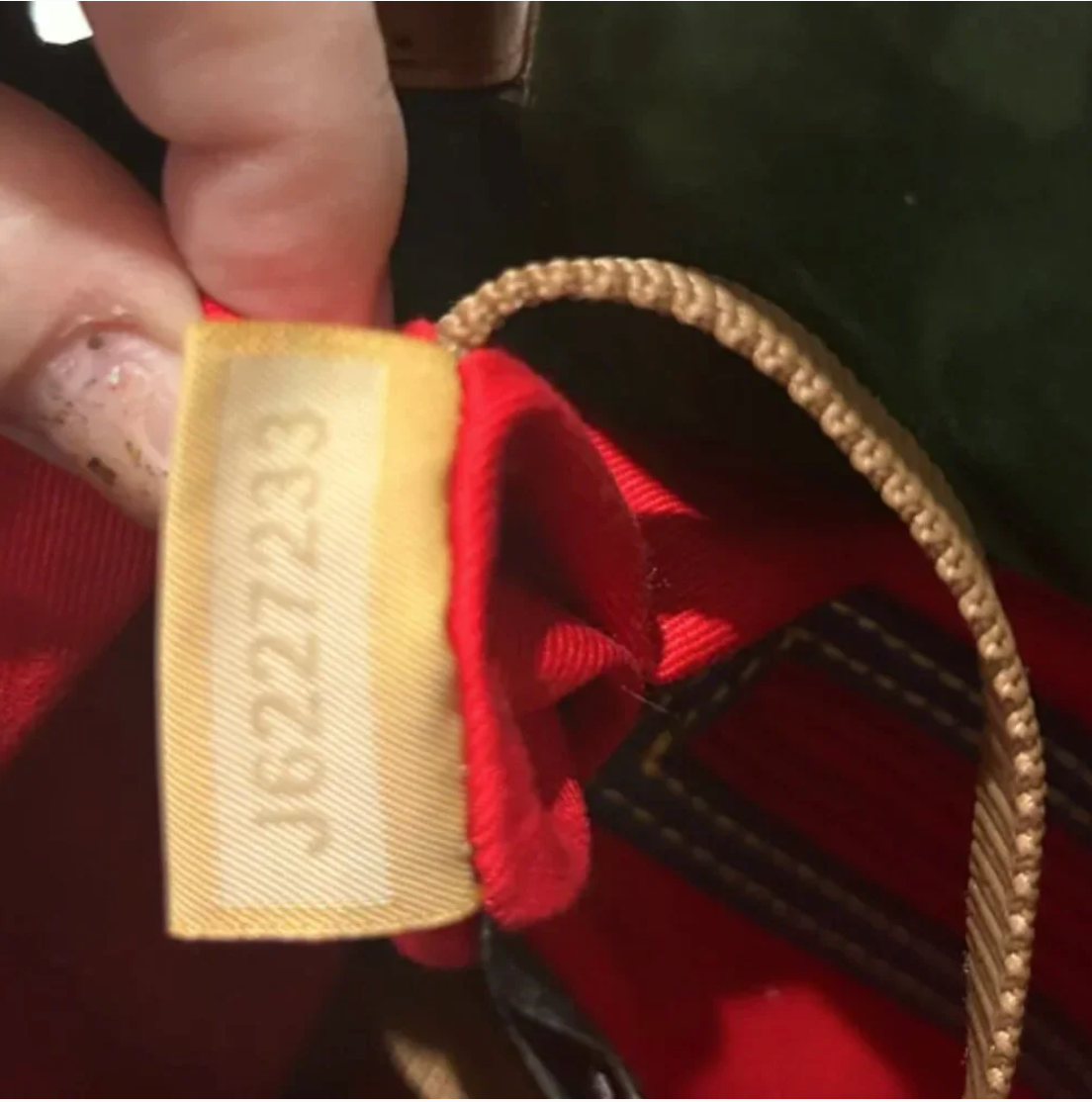 Close-up of a woven label on a red garment with visible text.