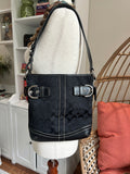 Black handbag with a silver lock on a white mannequin
