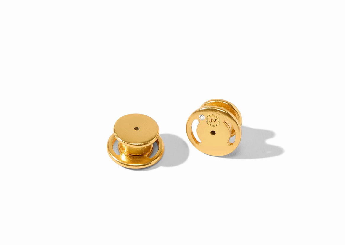 Gold earring backs on a white background