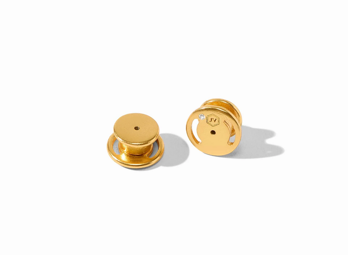 Gold earring backs on a white background