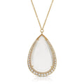 Teardrop-shaped monocle pendant on a gold necklace with matching frame and diamond accents on a white background