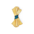 Gold brooch with blue feather center on a white background
