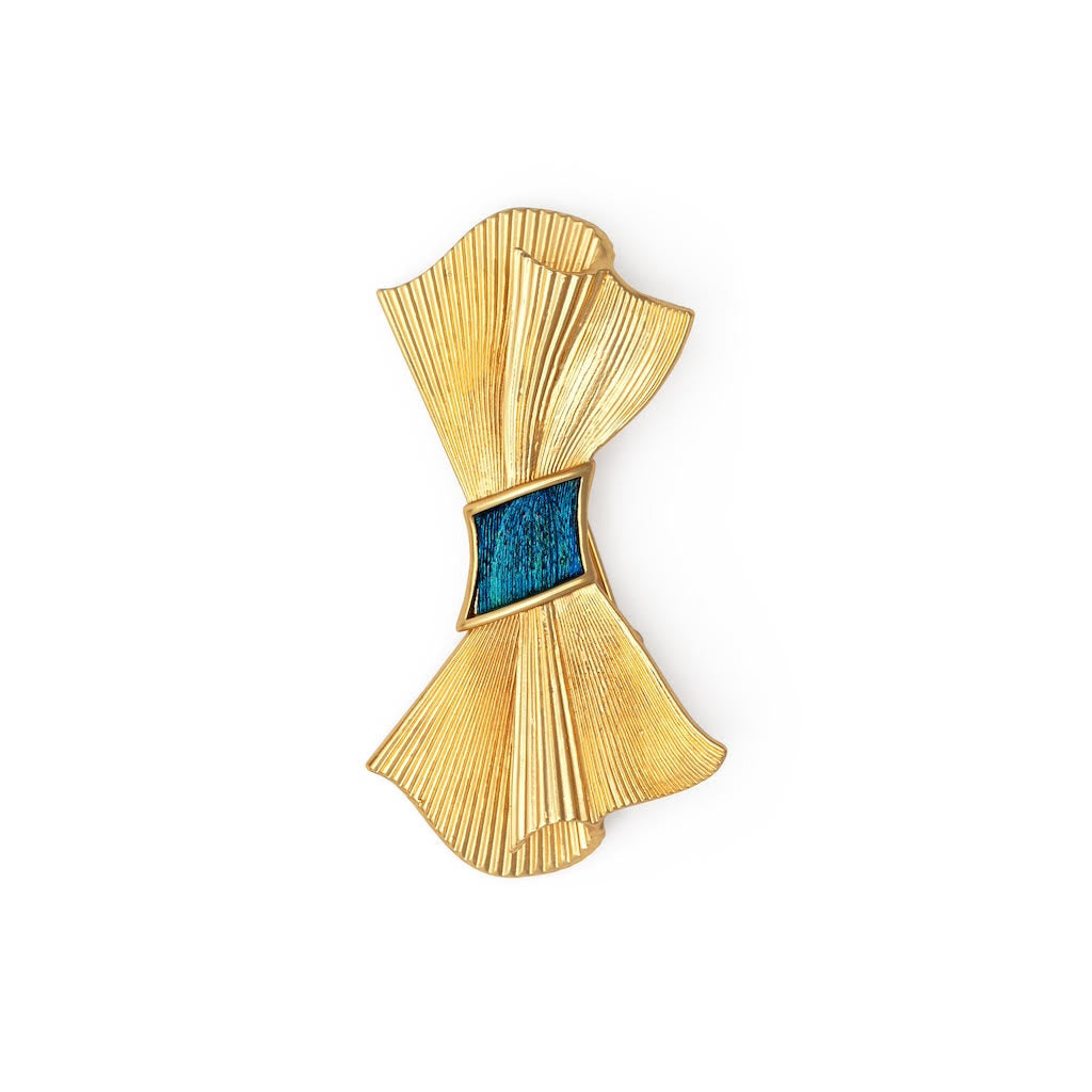 Gold brooch with blue feather center on a white background
