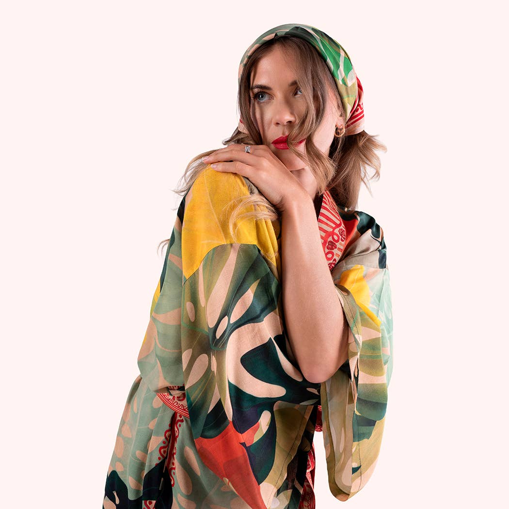 Woman wearing a colorful floral headscarf and dress on a white background