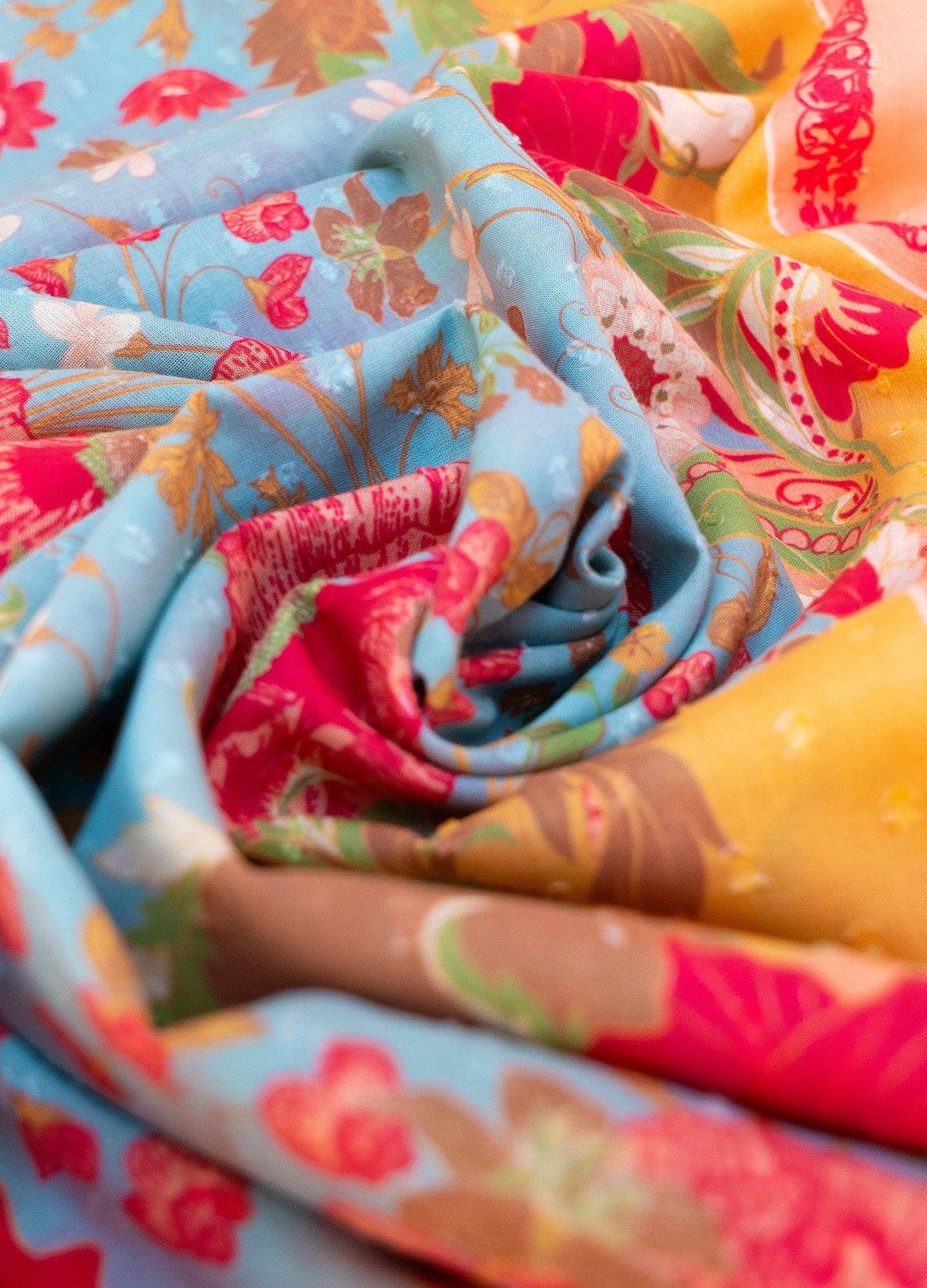 Close-up of colorful fabric with floral patterns in blue, red, and yellow.
