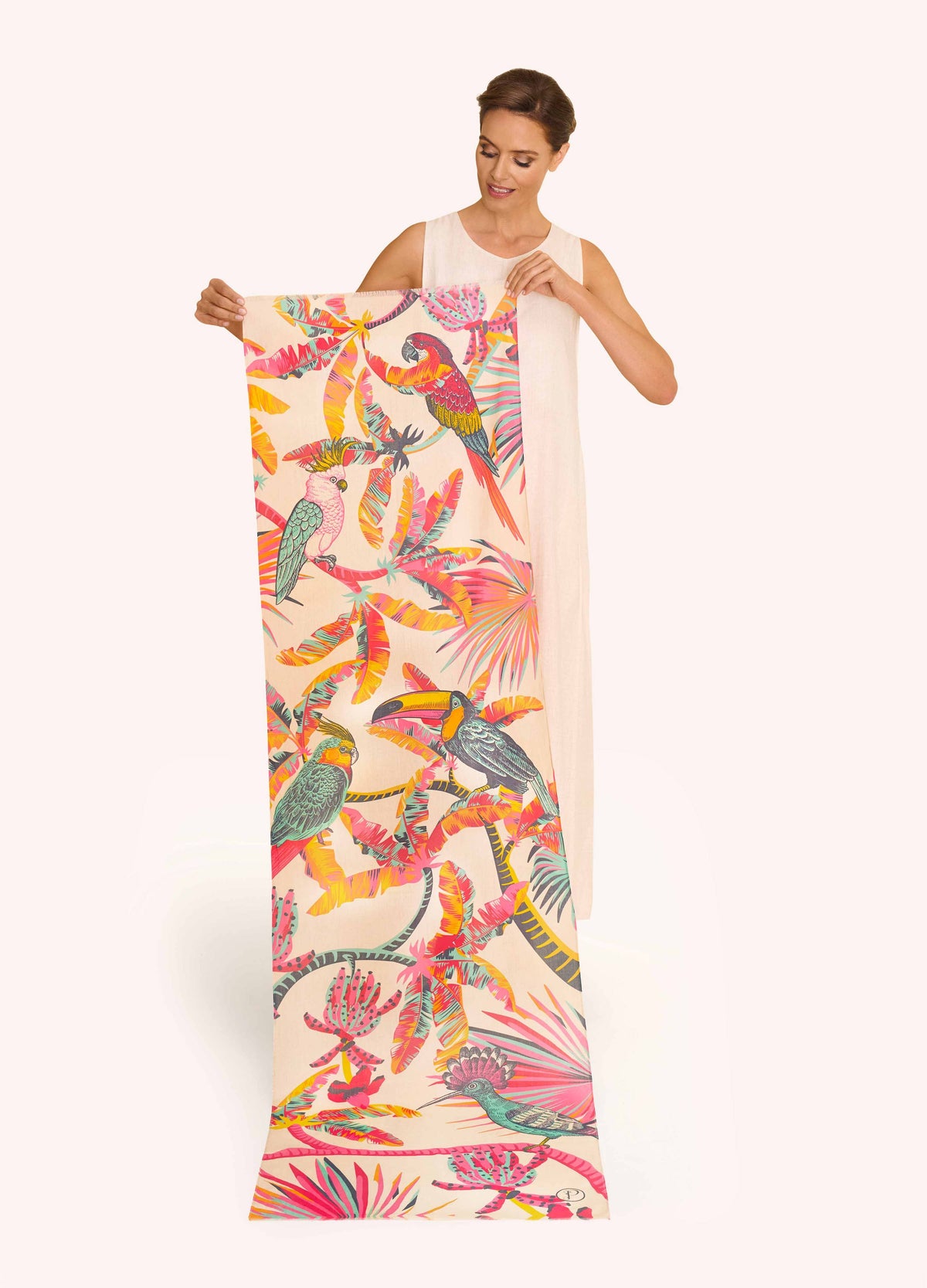 Woman holding a colorful tropical bird print scarf against a white background