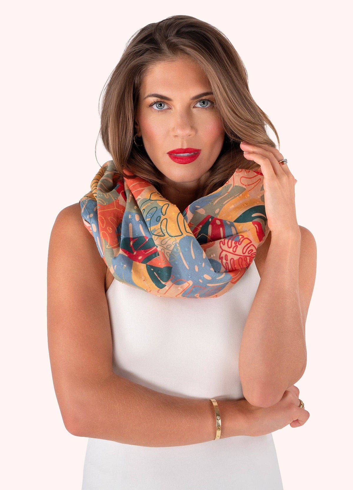 Woman wearing a colorful patterned scarf on a white background