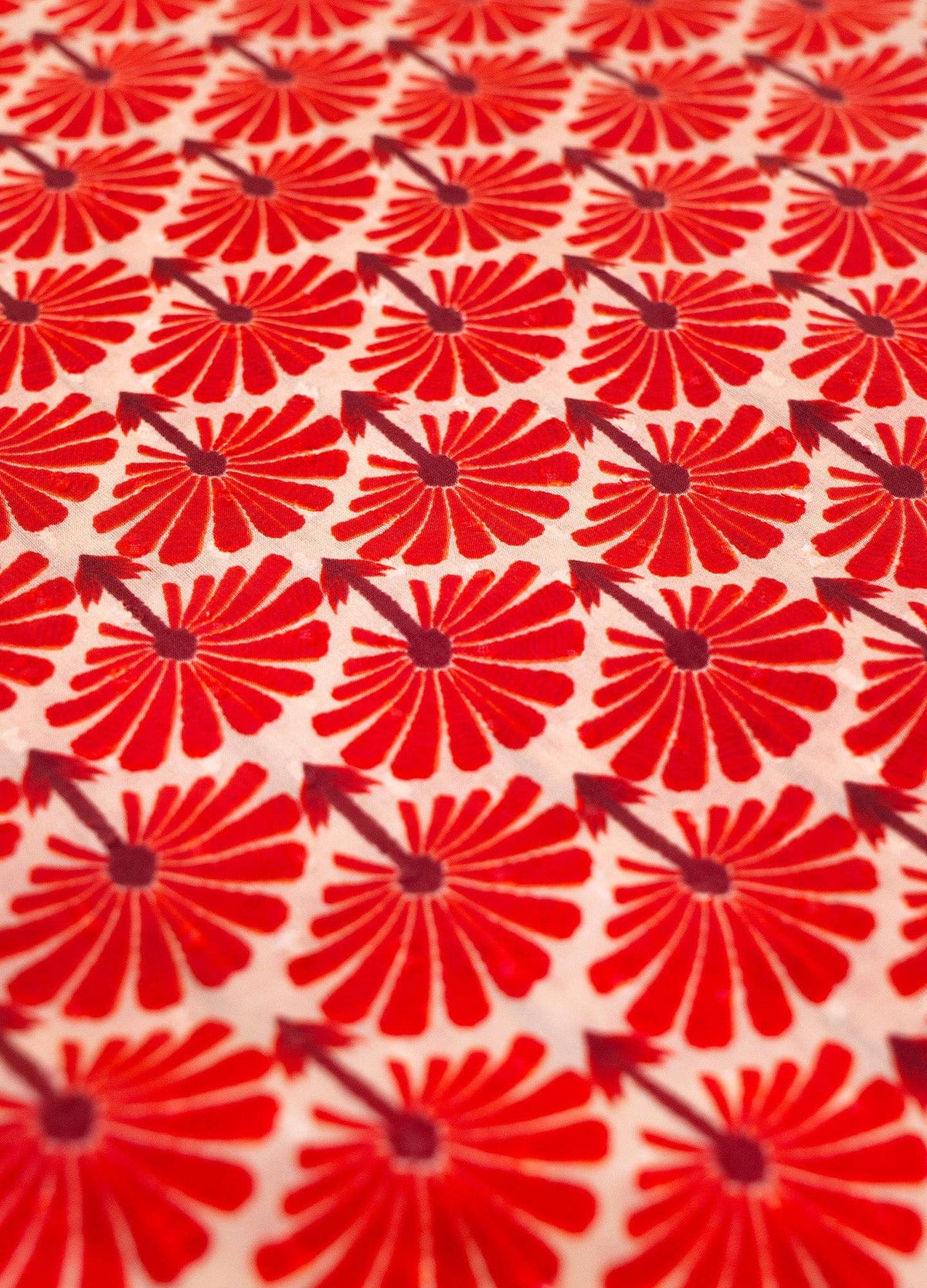Close up of fabric featuring a red floral pattern on a white background