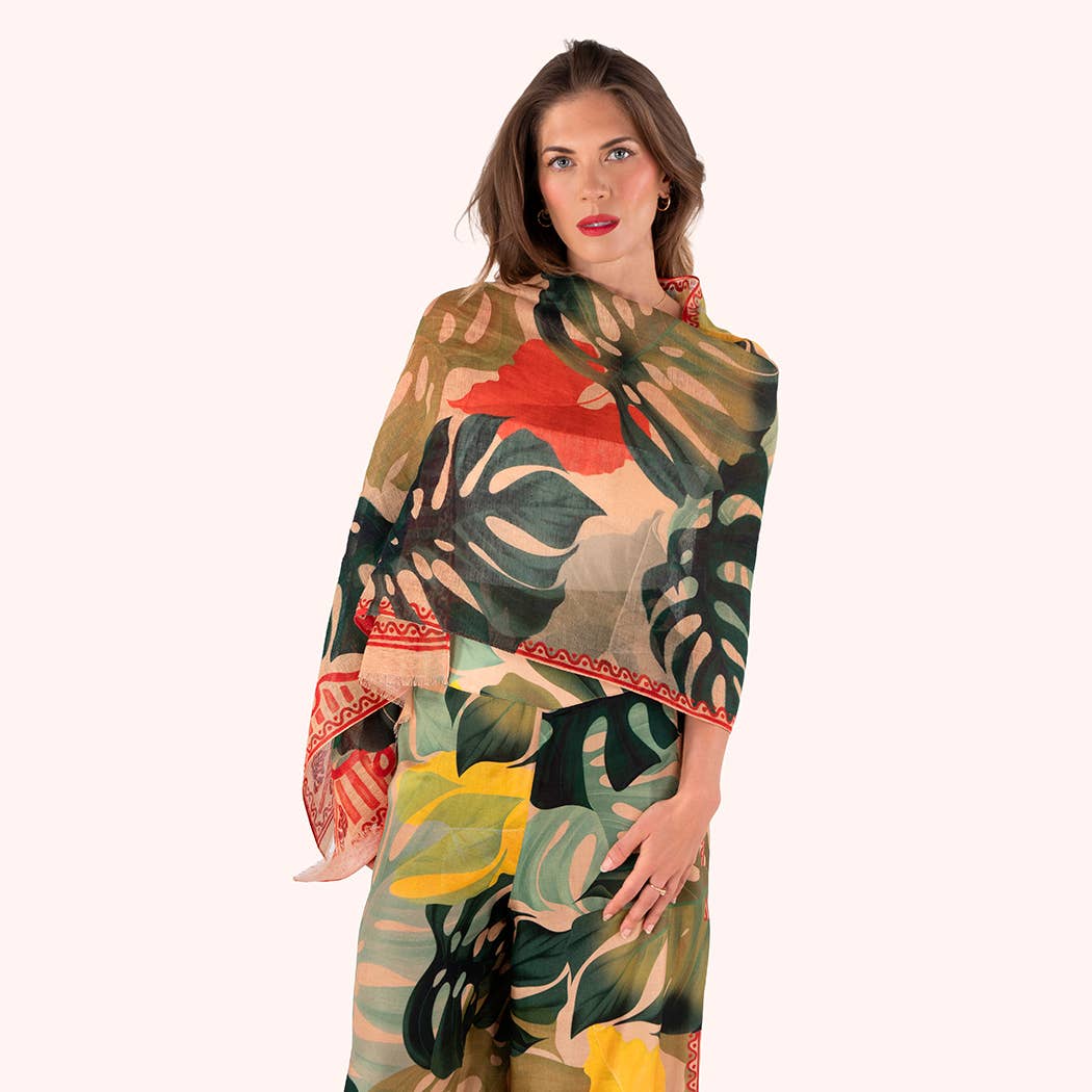 Woman wearing a colorful tropical leaf patterned scarf on a white background