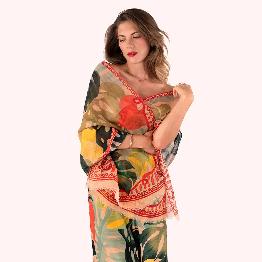 Woman wearing a colorful floral scarf with a patterned shawl on a white background