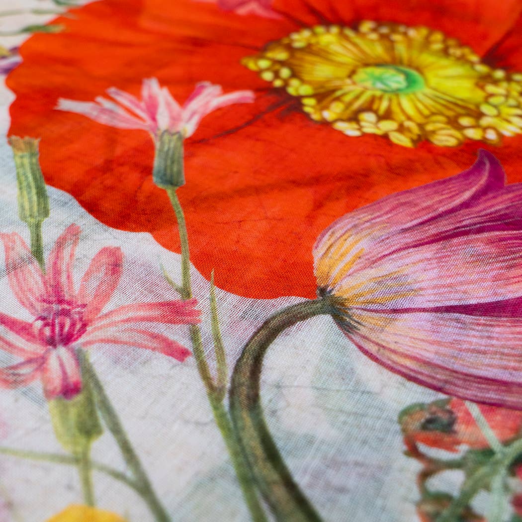 Close-up of a colorful floral design on fabric with red, pink, and yellow flowers.