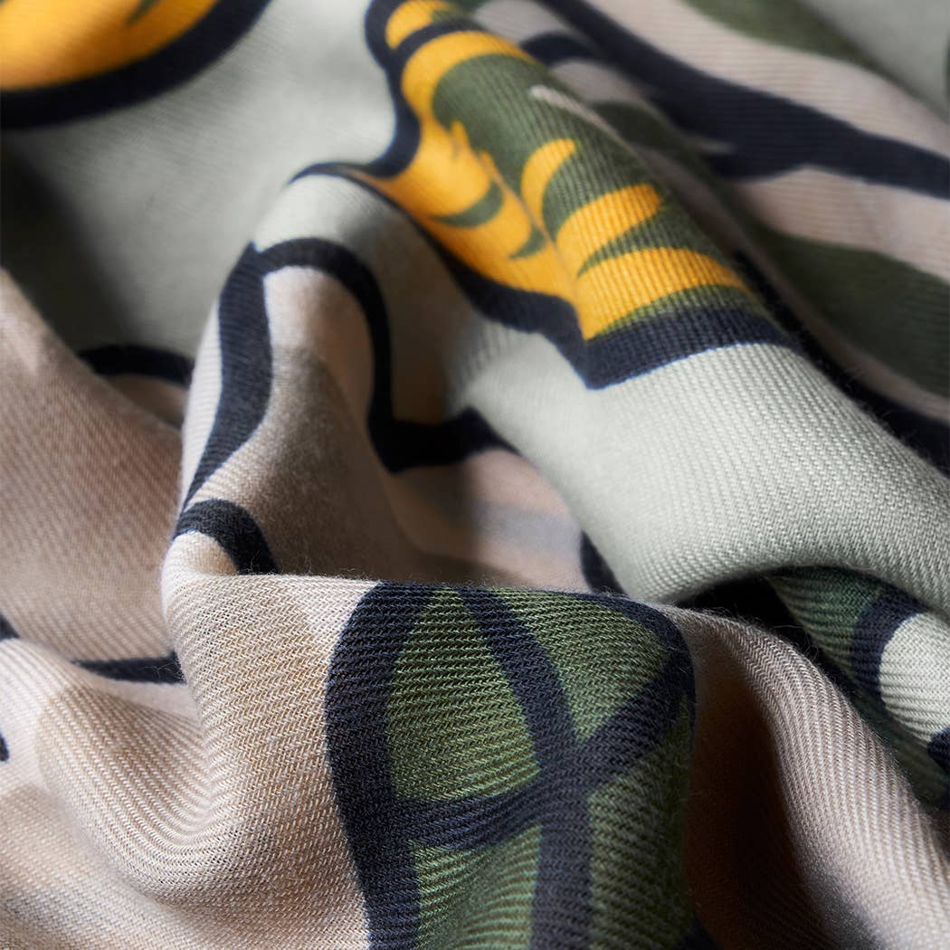 Close-up of scarf fabric with green, yellow, and beige floral design.