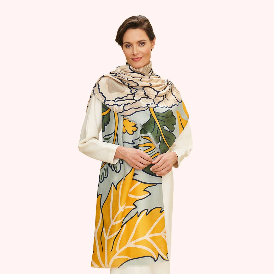 Woman wearing a floral patterned scarf with colors of green, yellow and beige on a white background
