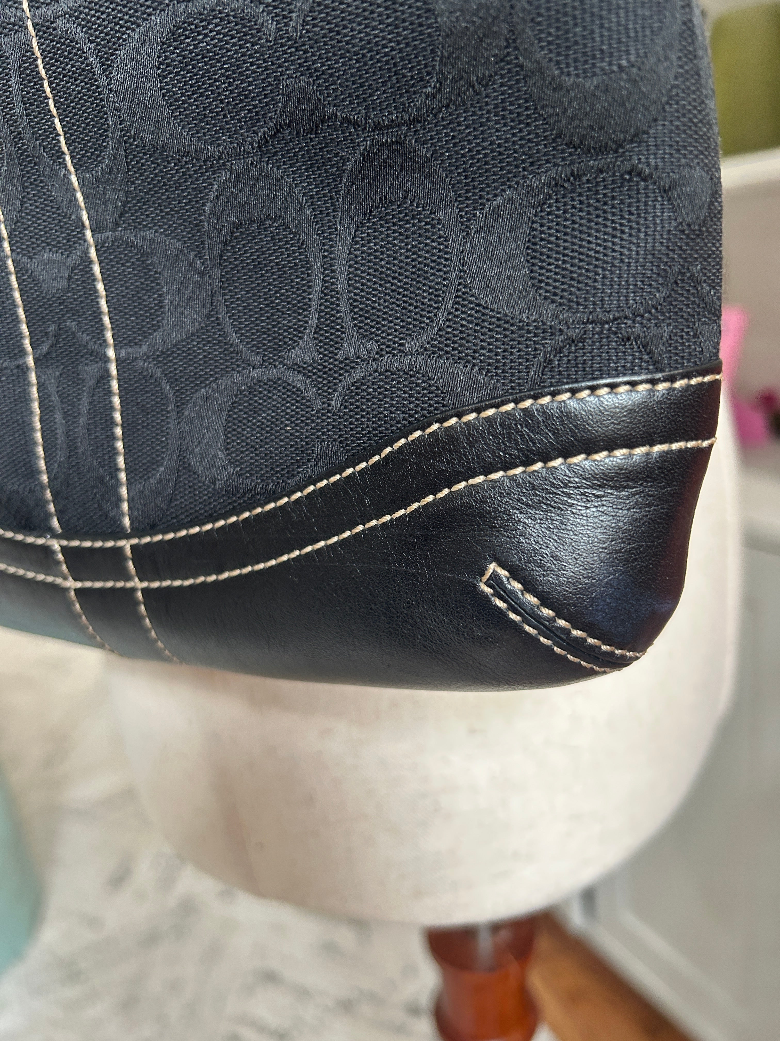 Close-up of a black leather product with white stitching on a blurred background
