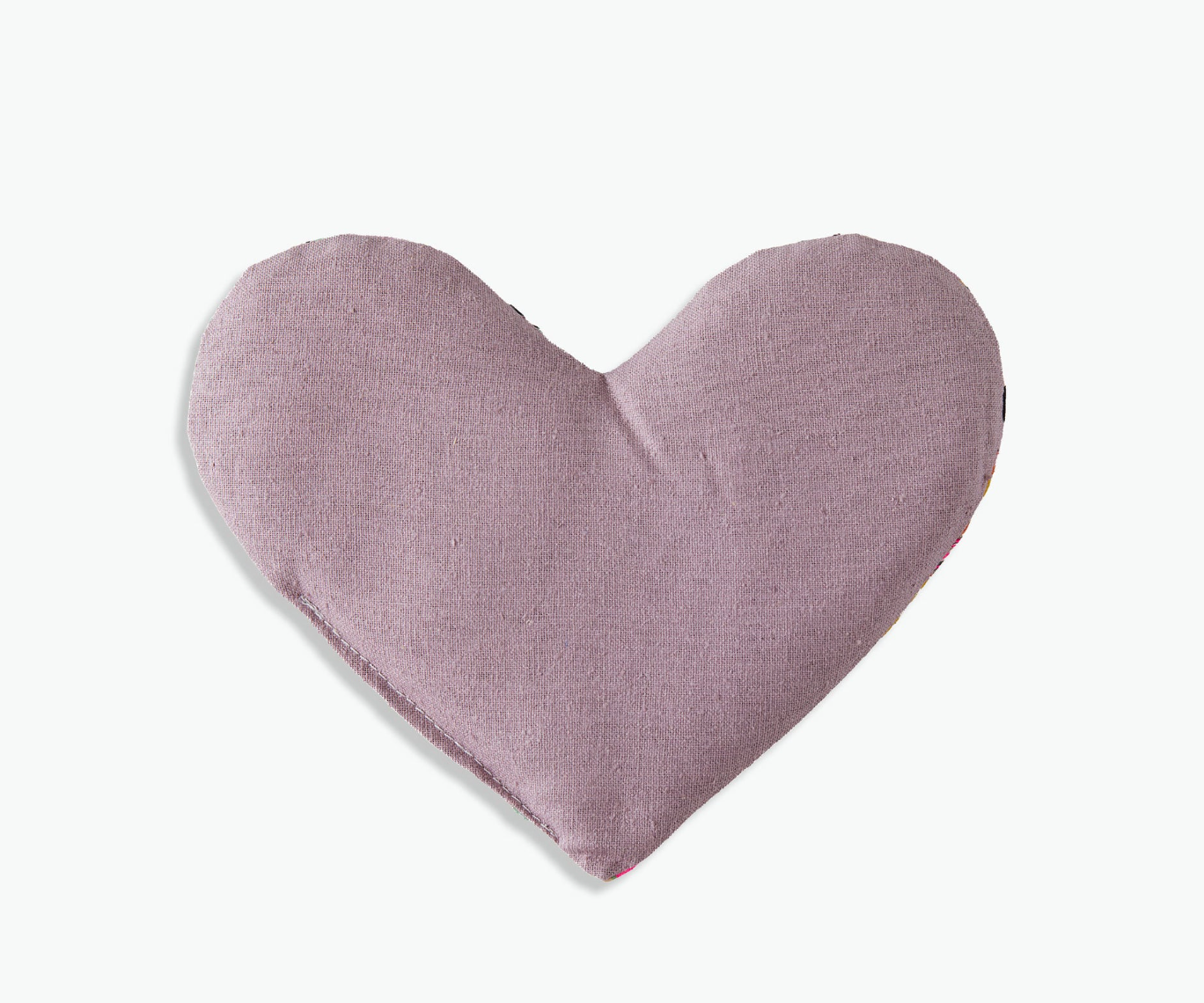 Heart-shaped pillow in a soft pink color on a light gray background