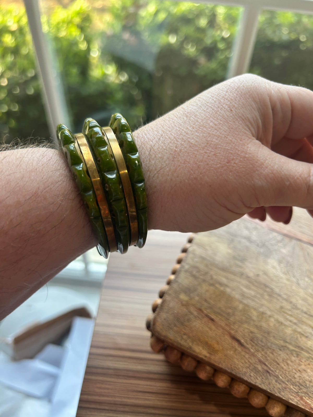 a green and brass bracelet on a woman's arm side view