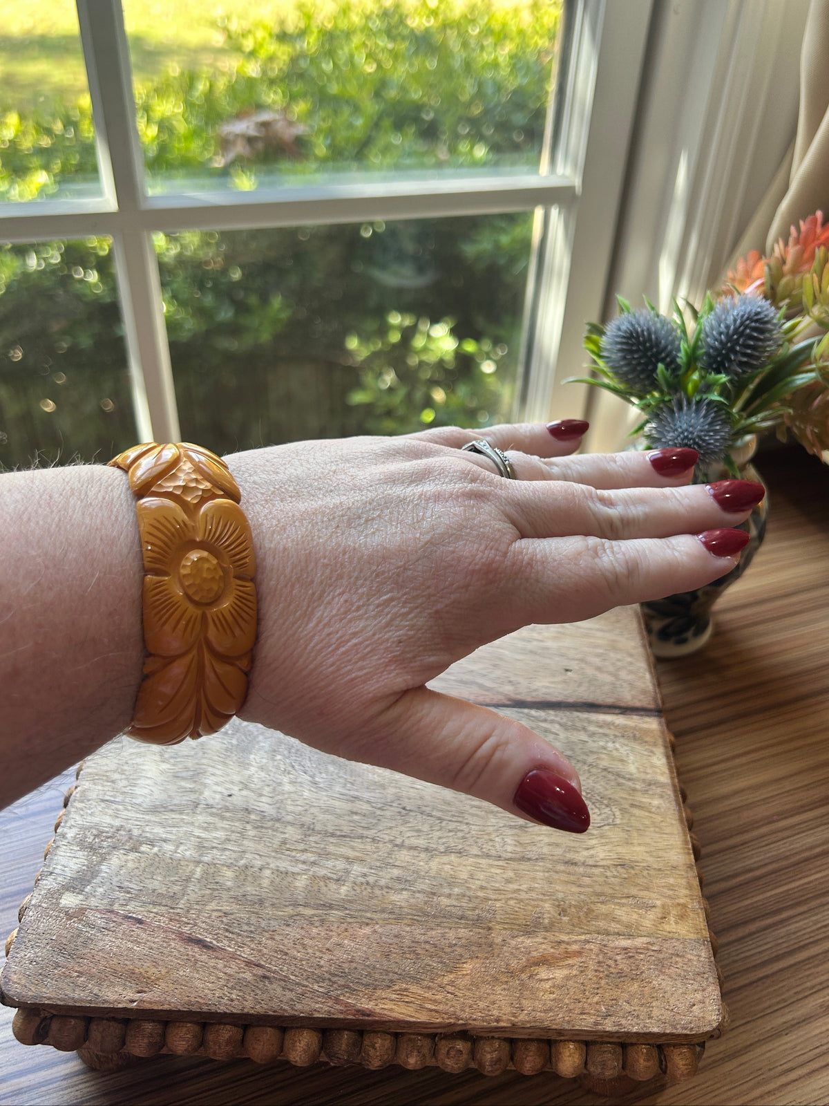 A carved golden yellow bracelet on a woman's arm
