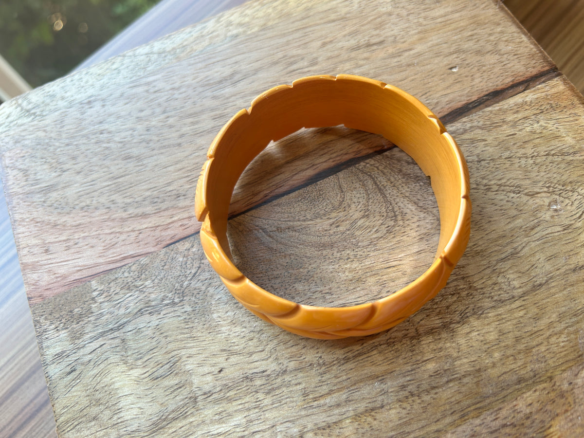 Top view of a golden bangle on a wood surface