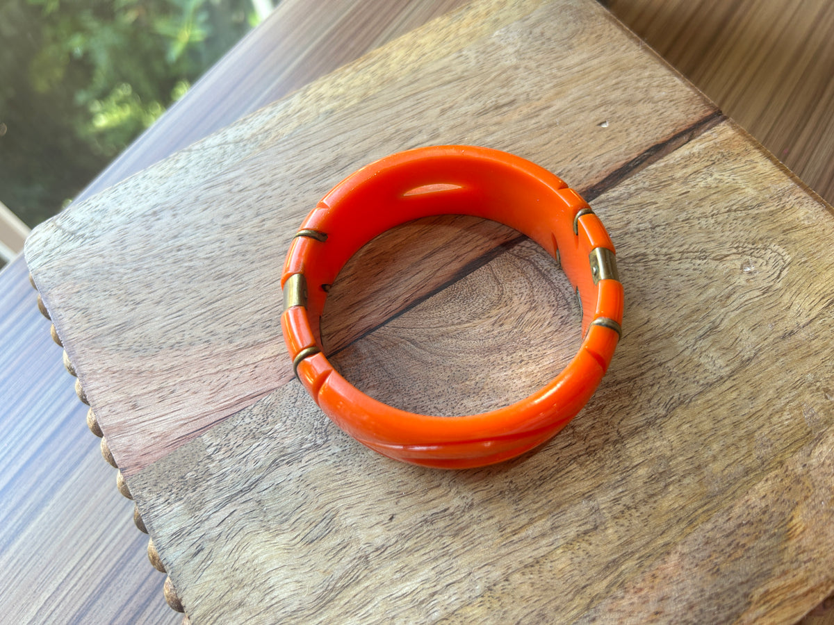 Top view of an orange bangle on a wood surface