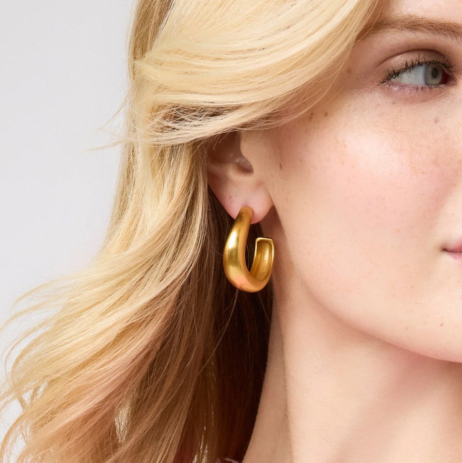 Model shown wearing a smooth gold hoop earring.