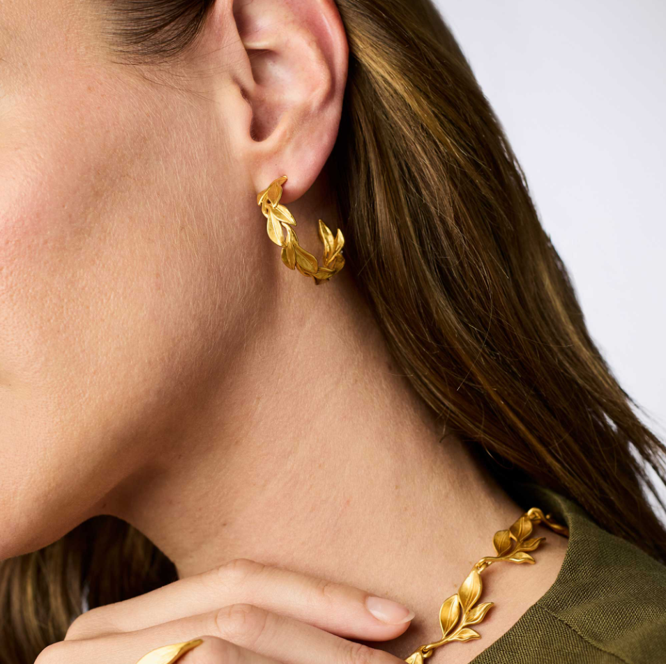 Model wearing a wreath-style gold hoop earring.